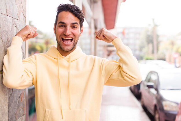 Ich fühle mich glücklich, zufrieden und kraftvoll, gebeugt und muskulöser Bizeps, der nach dem Fitnessstudio stark aussieht