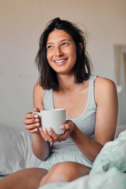 Ich kann es kaum erwarten zu sehen, was dieser Tag bringen wird Aufnahme einer jungen Frau, die zu Hause eine entspannende Tasse Kaffee im Bett genießt