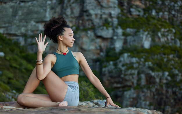 Ich kann mich biegen, drehen und im Chaos ruhig bleiben Aufnahme einer jungen Frau, die in den Bergen Yoga praktiziert