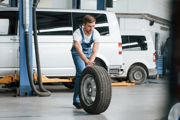 Ich komme gleich wieder. Mitarbeiter in der blau gefärbten Uniform arbeitet im Autosalon