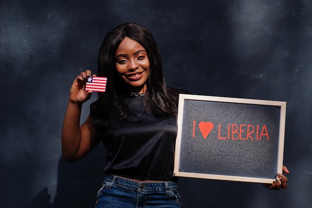 Ich liebe Liberia Modische afrikanische Frau hält Tafel mit liberianischer Flagge