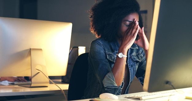 Ich muss nur damit fertig werden, kann jetzt keine Kopfschmerzen bekommen Schnappschuss einer schönen jungen Frau, die nachts in einem modernen Büro arbeitet