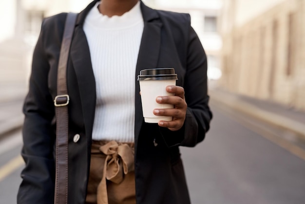 Ich nehme immer eine frische Tasse, bevor ich mit dem Pendeln beginne. Nahaufnahme einer nicht wiederzuerkennenden Geschäftsfrau, die eine Kaffeetasse hält, während sie in der Stadt ist