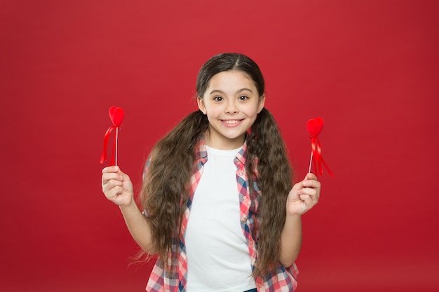 Ich werde Ihr Valentinsgruß sein Liebe und Familie Kindheitsglück glückliches kleines Mädchen Februarferien Kindertag Glückliches Kind mit rotem dekorativem Herzen Valentinstag Kleines Mädchen mit niedlichem Aussehen