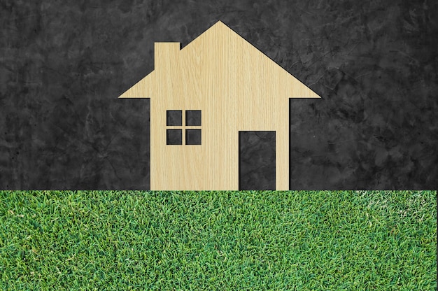 Ícone da casa de madeira no fundo da natureza da textura da grama como símbolo da casa de mortgagedream no fundo da natureza e espaço para seu texto