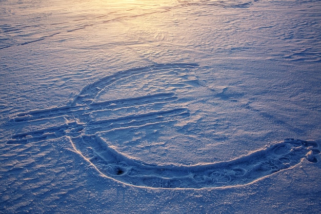 Ícone da moeda euro desenhado na neve. pôr do sol ao fundo.