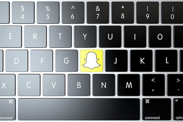 Ícone snapchat no teclado do laptop. conceito de tecnologia