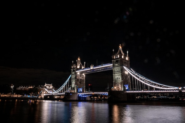 Icônica vista da tower bridge conectando londres com southwark ao longo do rio tamisa, reino unido. bela vista da ponte iluminada à noite.