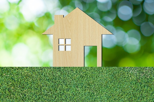 Icono de la casa de madera sobre fondo de naturaleza de textura de hierba como símbolo de hipoteca Casa de ensueño sobre fondo de naturaleza y espacio para su texto