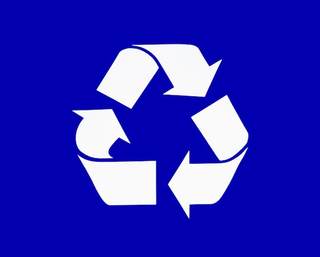 Foto icono de flecha reciclado sobre fondo azul.