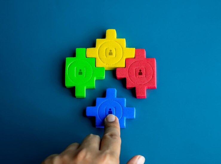 Foto el icono de la persona en los bloques de rompecabezas de diferentes colores se unen y se completan a mano en fondo azul asociación de negocios recursos humanos trabajo en equipo diferencia conceptos de unidad y colaboración