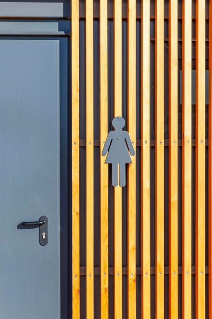 Un icono que indica un baño de mujeres con una puerta al baño Vista frontal vertical