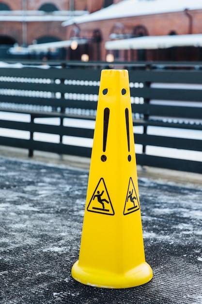 Icono resbaladizo en alertas de plástico amarillo sobre el peligro en la carretera. Precaución señal de advertencia húmeda.