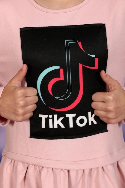 Foto Ícono de tik tok logotipo de redes sociales en camiseta de niña rosa. diseño de logotipo de tik tok.