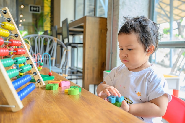 Idade pré-escolar asiática brincar com um brinquedo colorido sozinho. Jogo de educação para criança. Aprendizagem e estilo de vida do bebê.