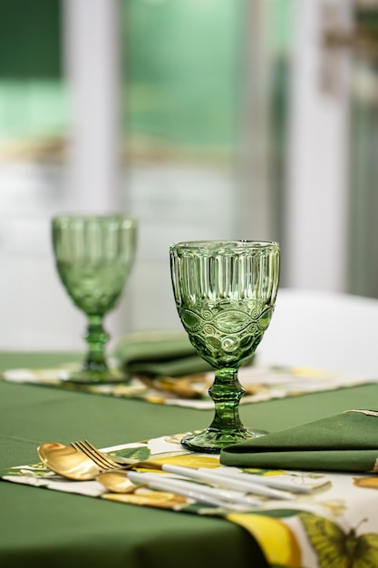 Idea de ajuste de la mesa de la cena con copas de vidrio verde con textura