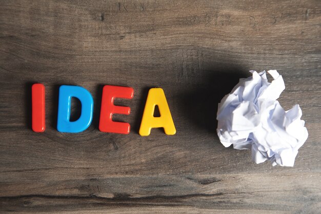 Idea de letras y papel arrugado sobre la mesa.