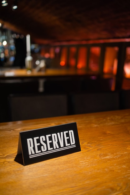 Una idea moderna para una mesa reservada con la inscripción Reserva de su lugar. Idea restaurantes la inscripción reservada en una mesa de madera en un café.