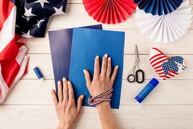 Foto idea de regalo, decoración 4 de julio, día de la independencia de estados unidos. tutorial paso a paso manualidades de bricolaje. hacer abanicos de papel de colores, paso 1: preparar todos los instrumentos, papel, pegamento, tijeras e hilo. vista superior plana endecha