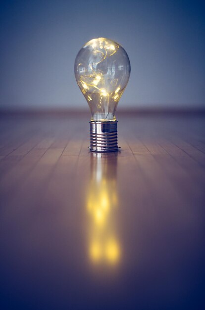 Ideas e innovación La bombilla con LED está tirada en el suelo de madera. Copiar espacio.