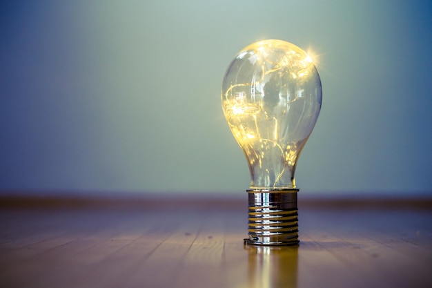 Ideas e innovación La bombilla con LED está tirada en el suelo de madera. Copiar espacio.