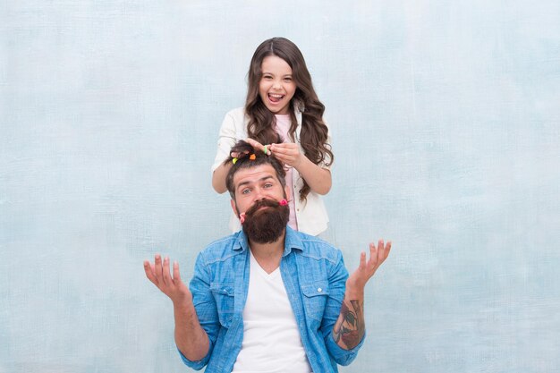 Foto ideas para entretener a los niños durante la cuarentena concepto de ocio familiar peinado de papá niña cuarentena con niños familia feliz infancia feliz crianza hija feliz hija jugando con el cabello