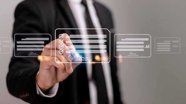 Ideas para un lugar de trabajo sin papel que exige la gestión de documentos con firma electrónica Un empresario firma un documento electrónico en un documento digital en una pantalla virtual utilizando un bolígrafo