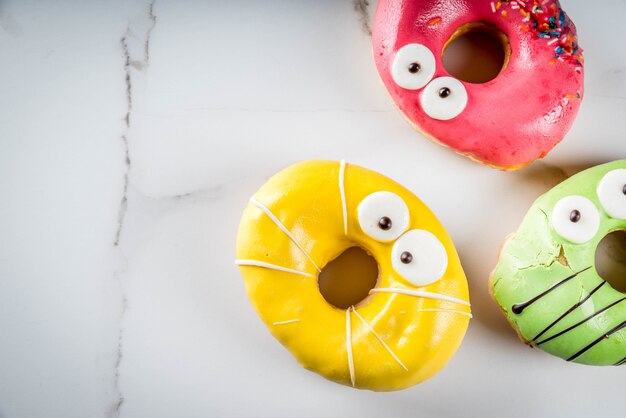 Ideas para niños trata en Halloween. Donuts de colores en forma de monstruos