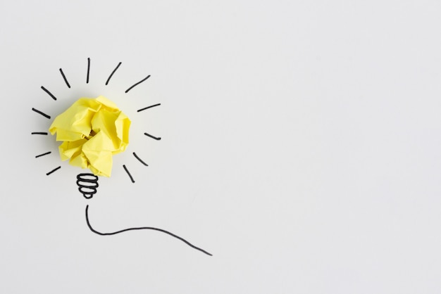 Ideia criativa de lâmpada de papel amarelo arrugado em fundo branco