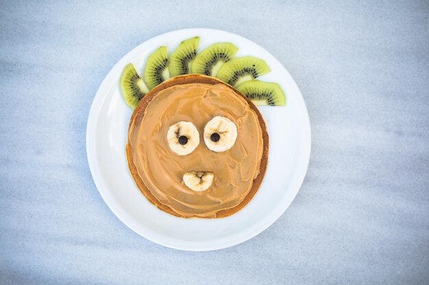 Ideia criativa para o café da manhã das crianças Panquecas em forma de urso com bagas na mesa de mármore vista de cima Comida saudável para crianças Comida engraçada para crianças