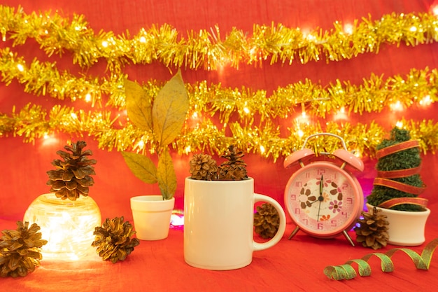 Ideia de conceito minimalista exibindo produtos. caneca de café no fundo de Natal e ano novo. vermelho, luzes, flores de pinho