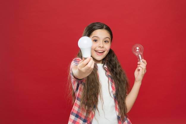 Ideia e conceito de brainstorming Menina adorável criança com cabelo comprido segura lâmpadas Ideia e criatividade Nova ideia da geração de jovens Algo em sua mente Criança menina feliz com a ideia