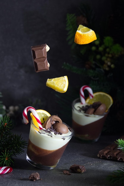 Ideia para uma sobremesa de Natal. Mousse de chocolate em uma decoração festiva de Natal com frutas levitando