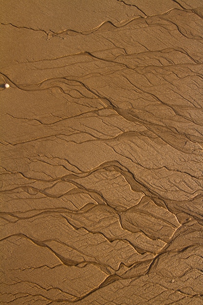 Ideia superior de linhas textured fundo na areia na praia criada pela maré baixa.