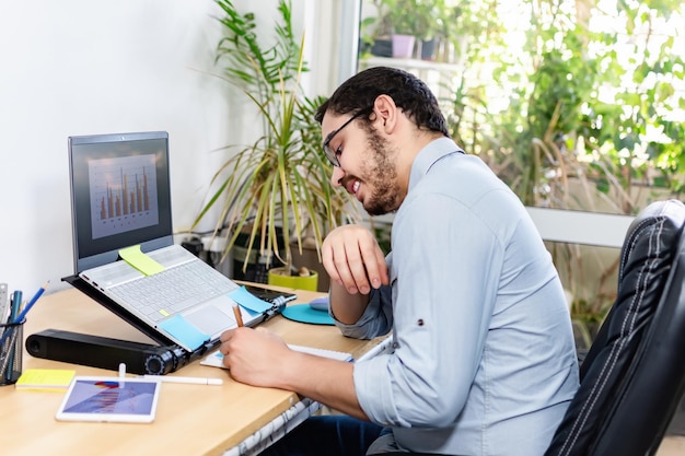 Ideias de negócios de escrita profissional feliz no bloco de notas na mesa