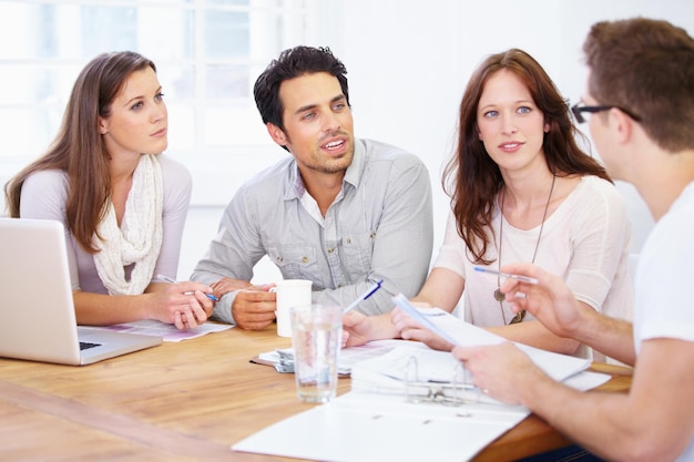 Ideias de negócios dinâmicas Foto de um grupo de jovens profissionais de design sentados em uma mesa e tendo uma sessão de brainstorming