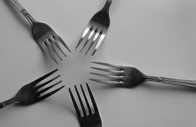 Idênticos garfos de mesa prateados em forma de estrela Foto de conceito para design ou fundos
