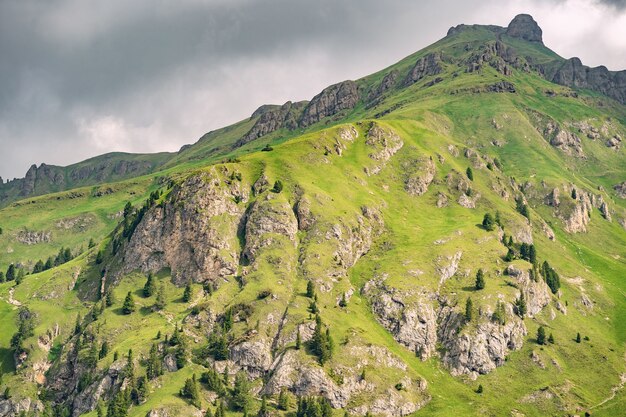 Idílico paisaje con alta colina verde bajo el cielo