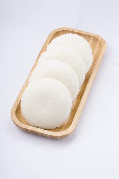 Idly o Idli, artículo principal del desayuno del sur de la India, bellamente dispuesto en una base de madera colocada