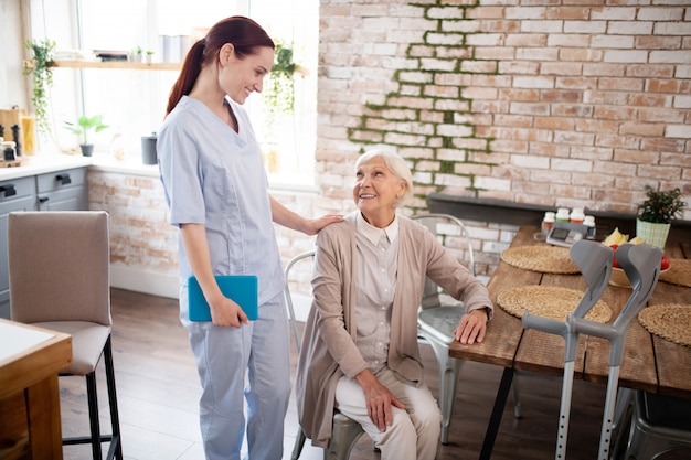 Foto idosa a falar com a sua atenciosa enfermeira