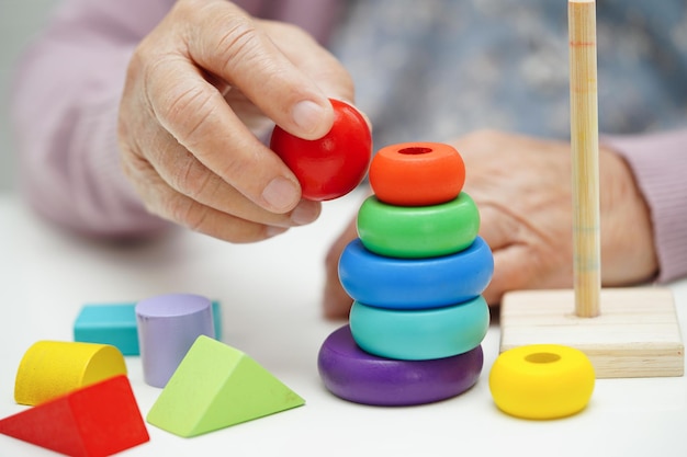 Idosa asiática jogando jogo de quebra-cabeças para praticar treinamento cerebral para prevenção de demência doença de Alzheimer