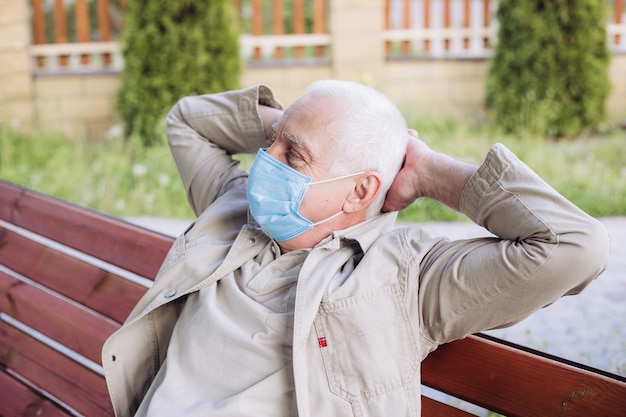 Idoso doente usando máscara protetora contra doenças infecciosas transmissíveis e como proteção contra gripe em público e transporte