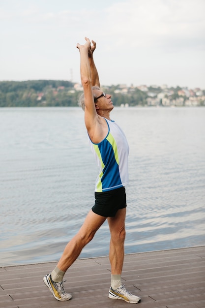 Idoso pratica esportes na margem do lago