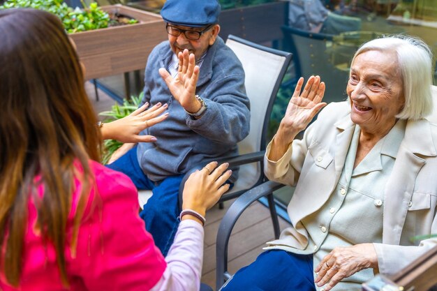 Foto idosos a divertirem-se com uma enfermeira num geriátrico.