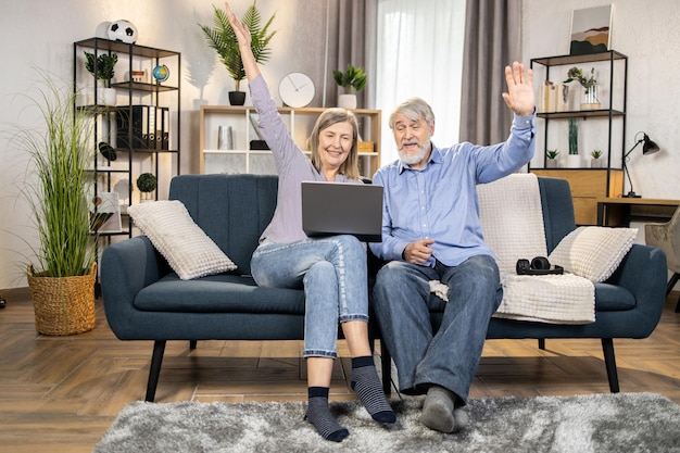 Idosos assistindo vídeo no laptop na sala de estar