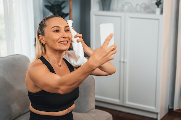 Idosos ativos e esportivos tiram selfie com smartphone depois de terminar o exercício em casa Estilo de vida corporal saudável e em forma para aposentado após treino de aposentadoria se exercitando em casa Influência