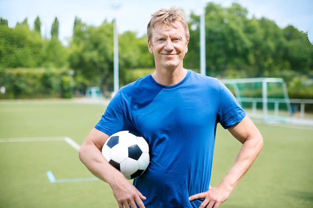 Idosos felizes com um estoque de futebol ao ar livre