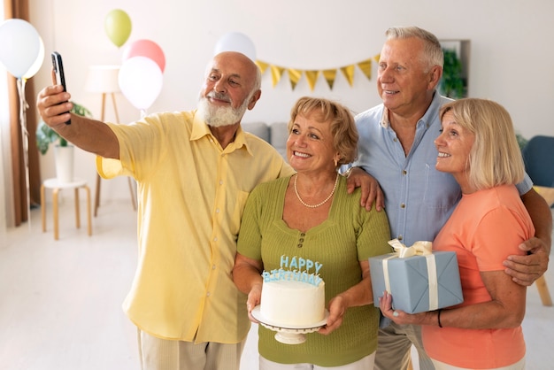 Foto idosos tirando selfie na festa de aniversário