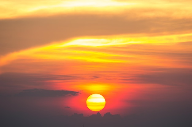 Idyllische Aufnahme der Sonne am orangefarbenen Himmel beim Sonnenuntergang
