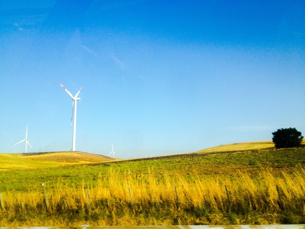 Idyllische Aufnahme eines Ackerfeldes mit Windturbine gegen den Himmel